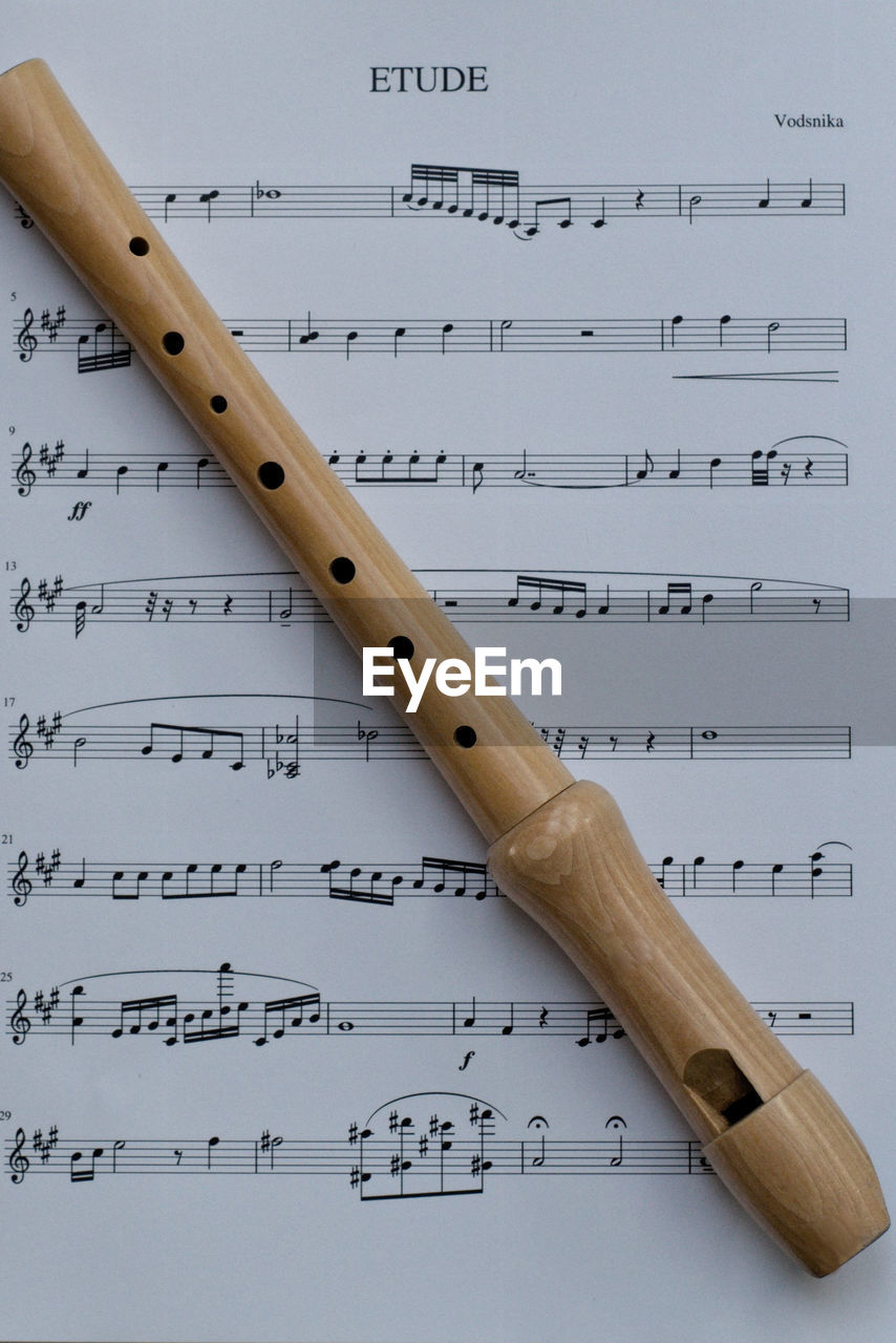 Directly above shot of flute on sheet music
