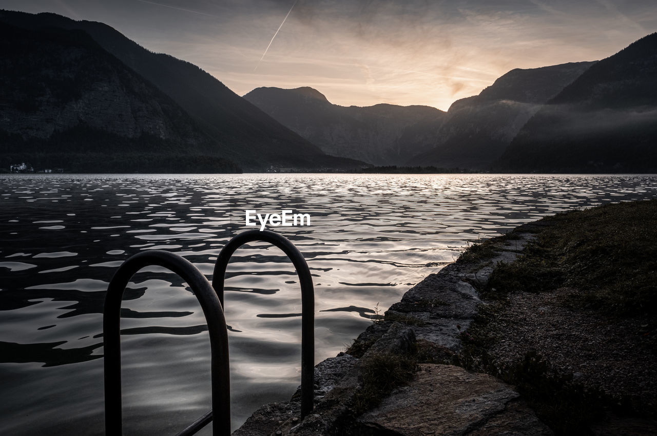 Scenic view of lake against mountains during sunset