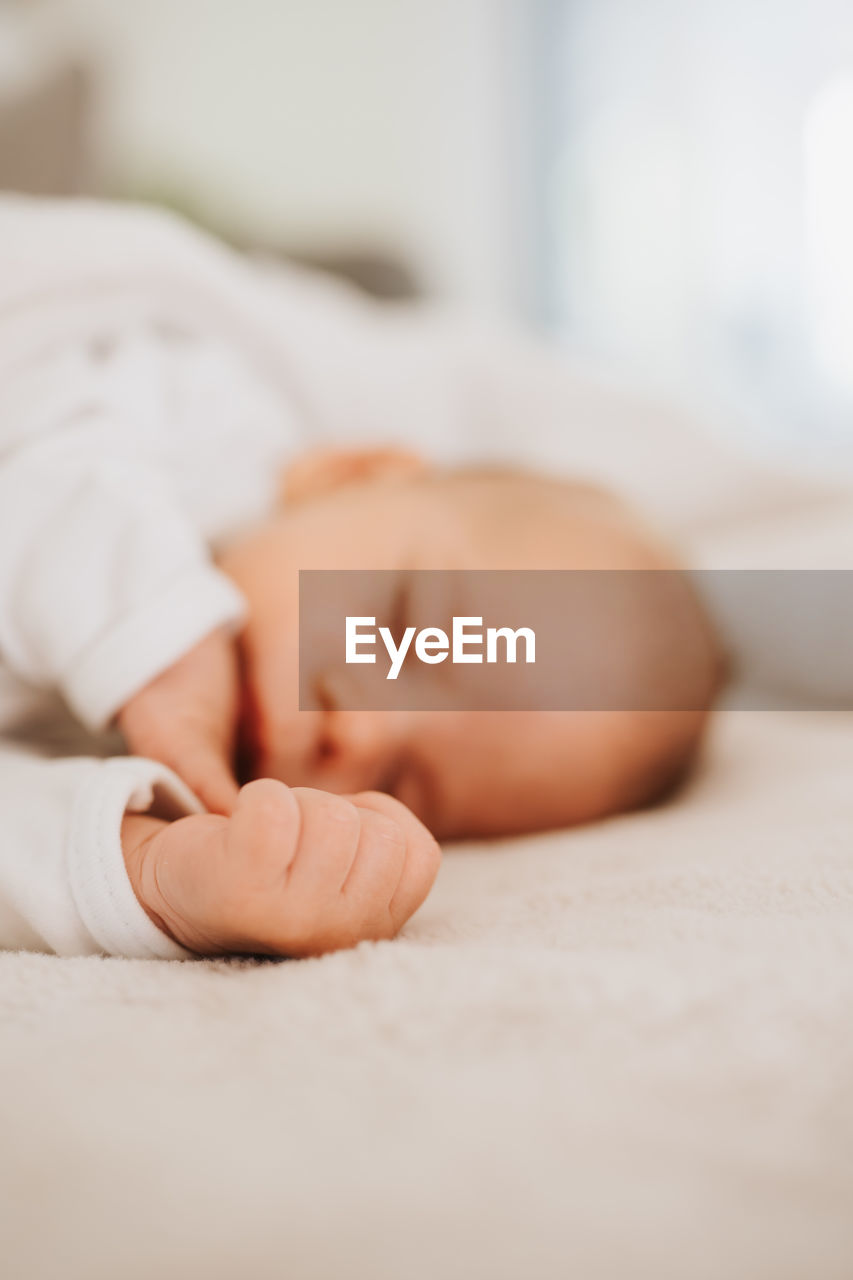 Close-up of cute baby boy sleeping on bed at home