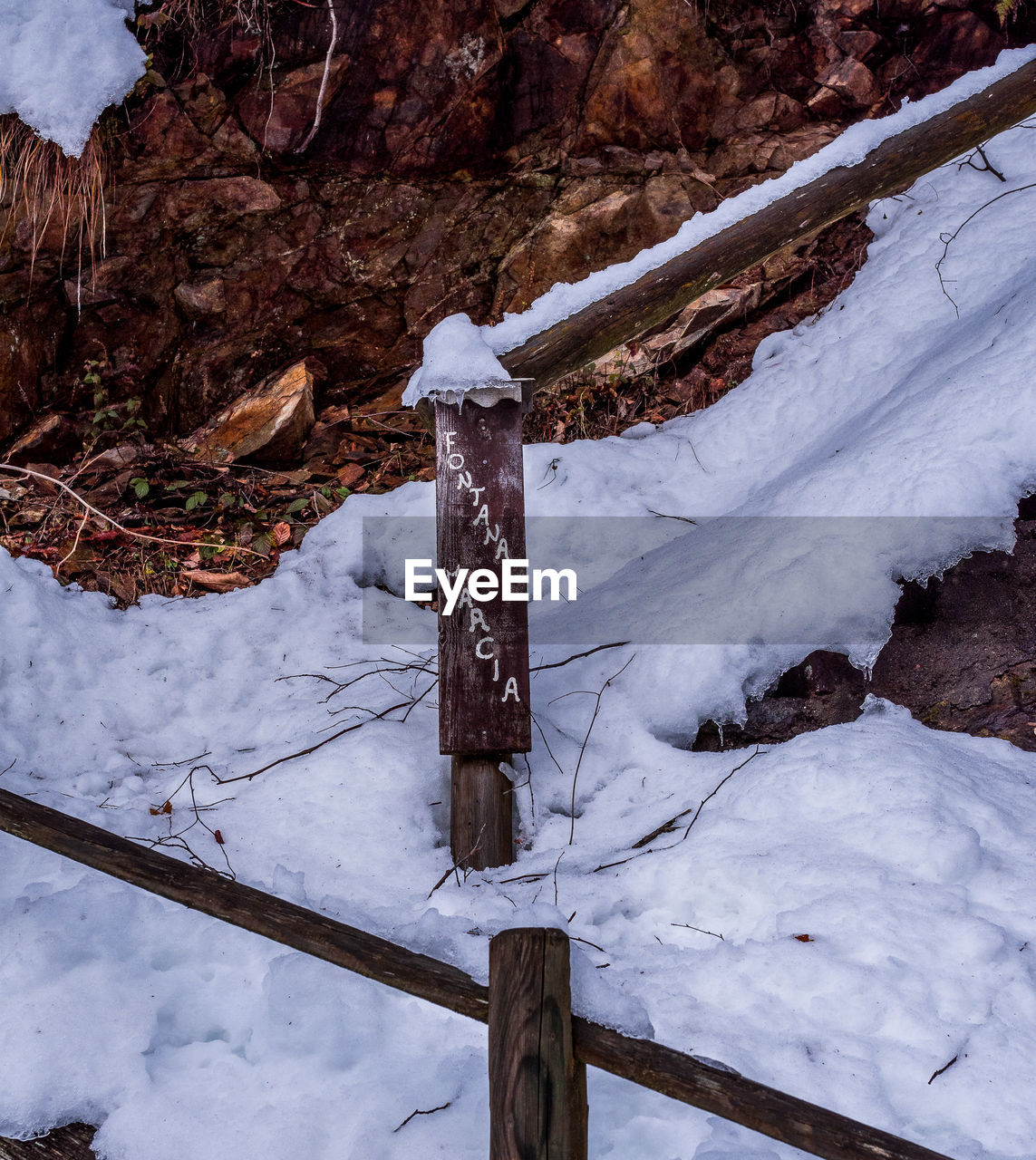 SNOW COVERED LAND BY MOUNTAIN