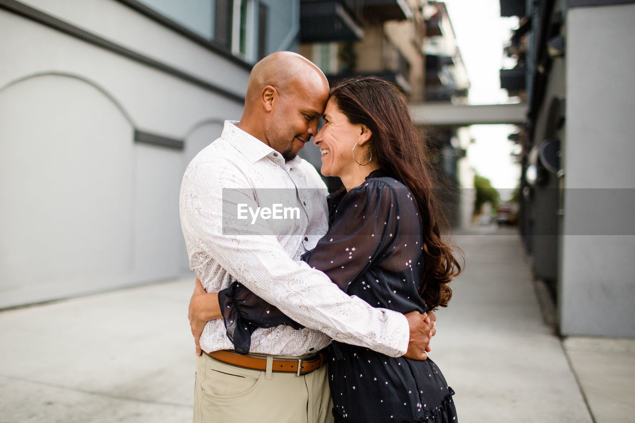 Late forties couple embracing in alley in san diego