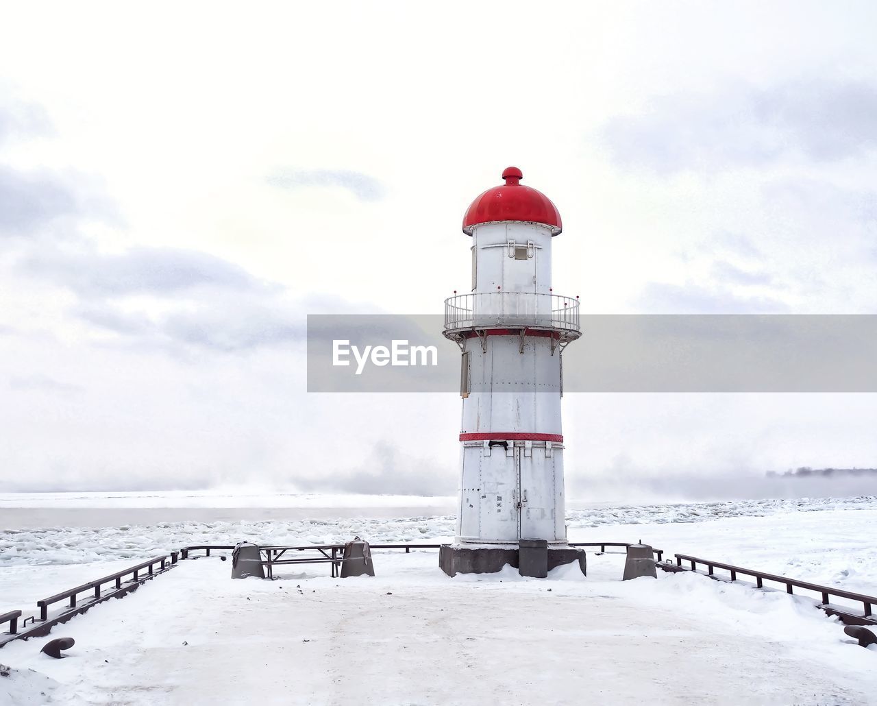 Lighthouse by sea against sky