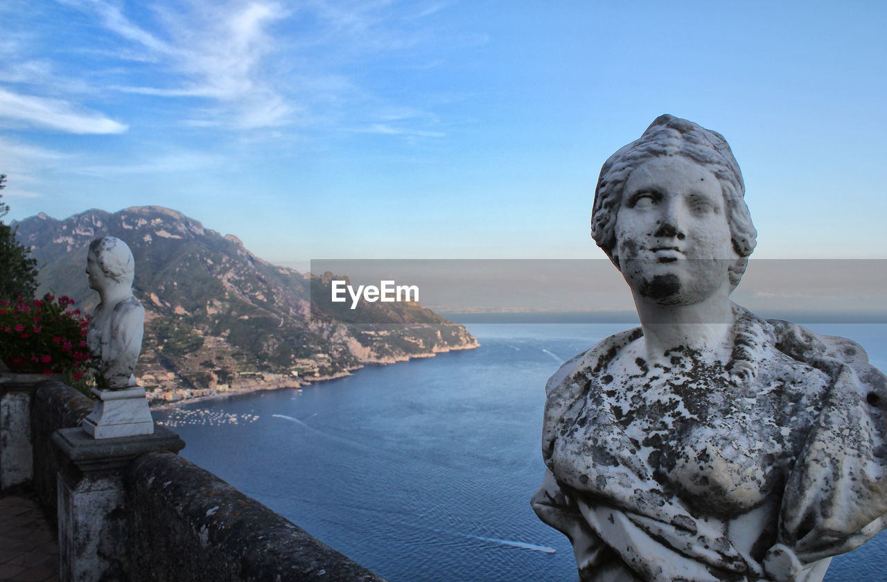 STATUE AMIDST SEA AGAINST SKY