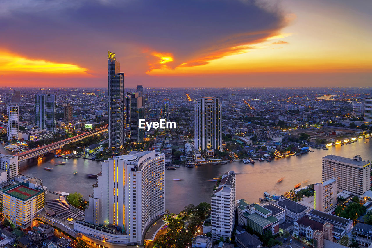 High angle view of modern buildings against sky during sunset