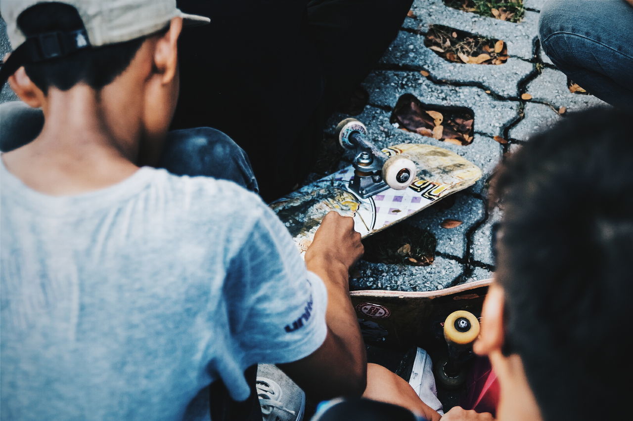 People repairing skateboard on street
