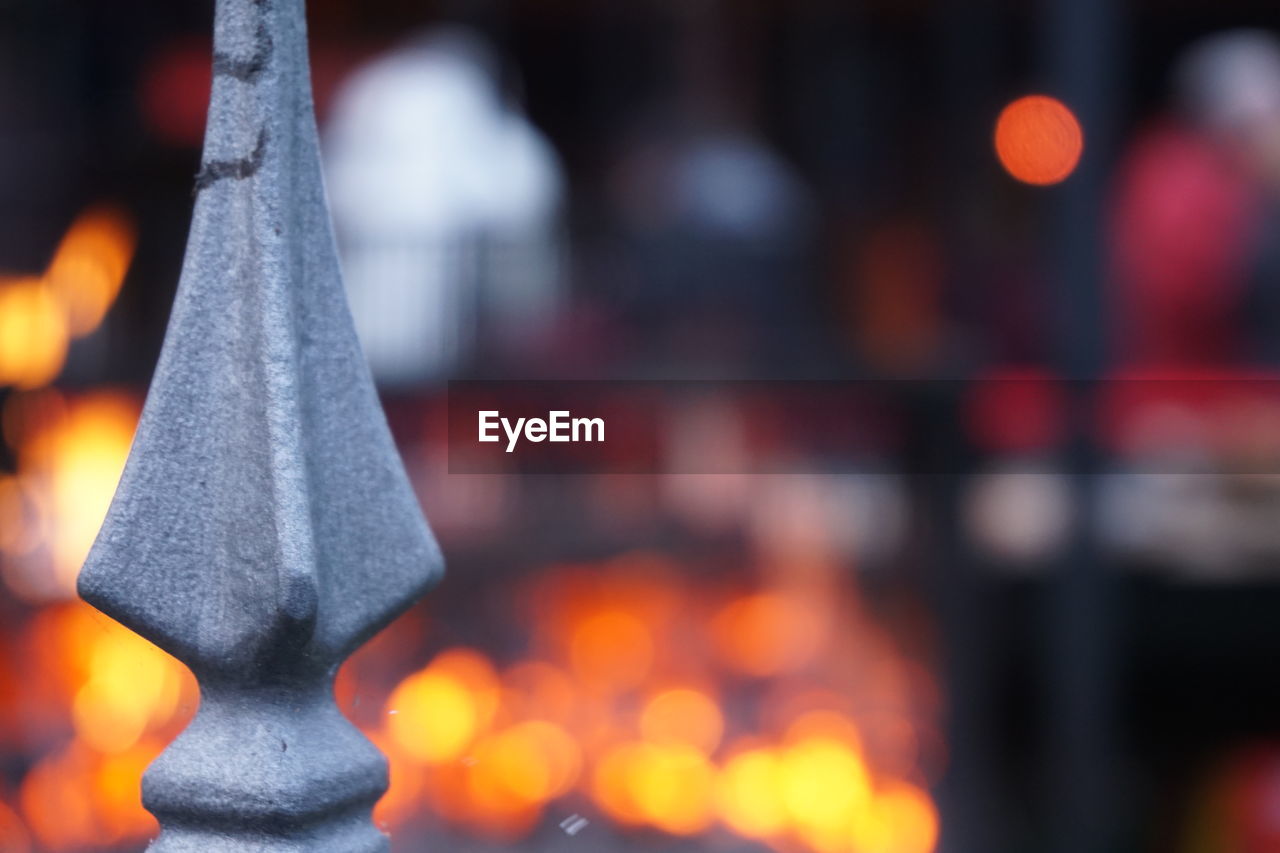 Close-up of gate with fire pit in background