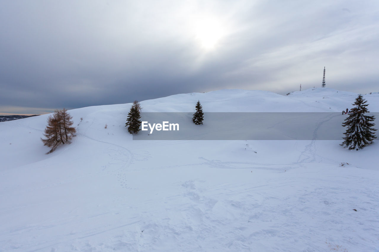 Scenic view of snow covered field against sky