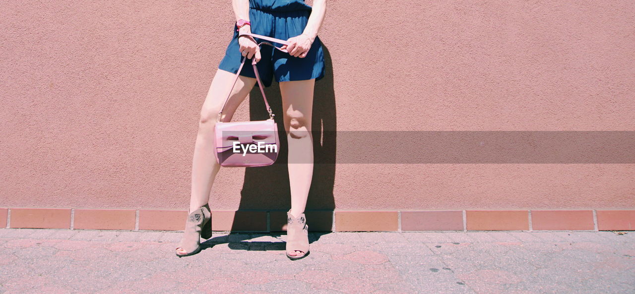 Low section of woman standing on wall