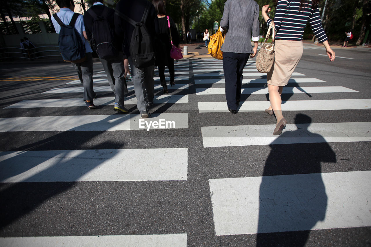 Low section of people walking on crosswalk