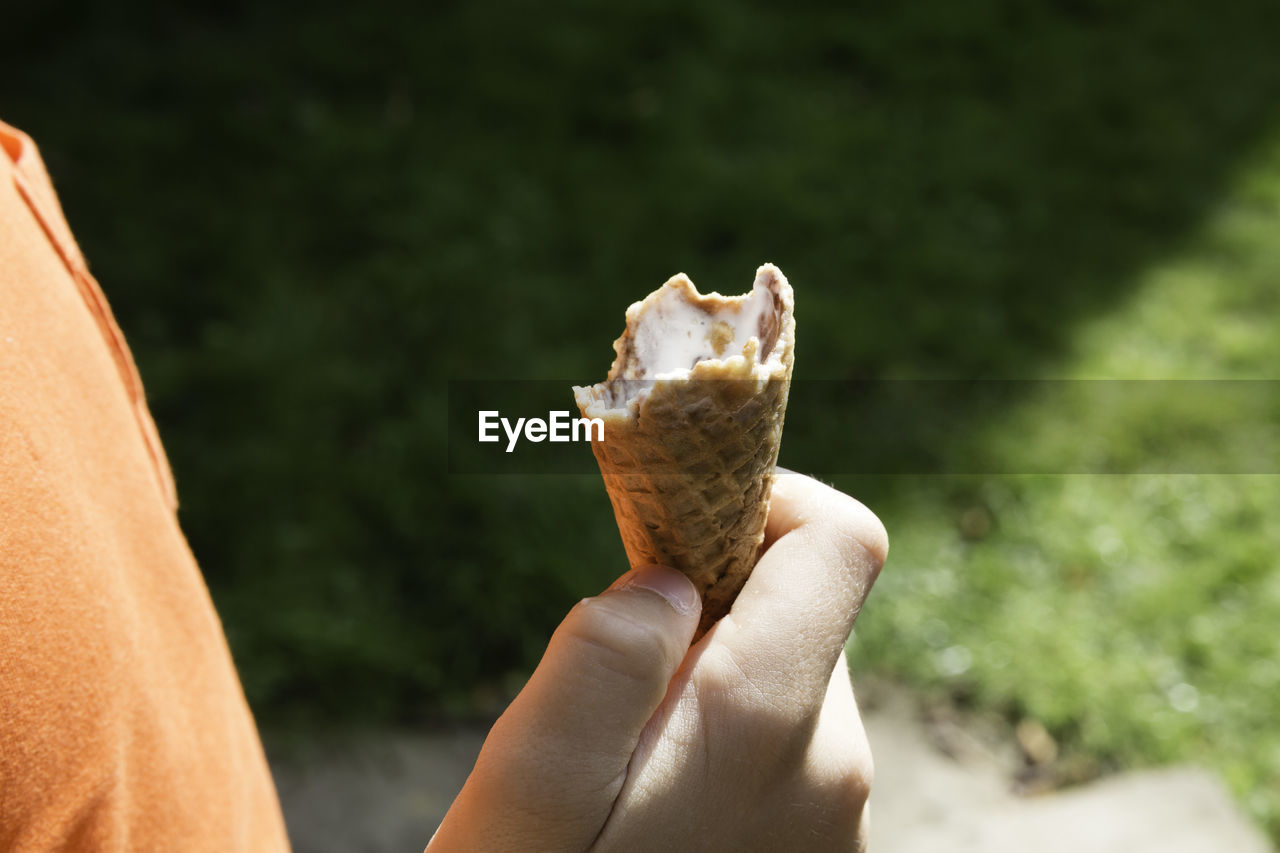 CLOSE-UP OF WOMAN HOLDING ICE CREAM CONE