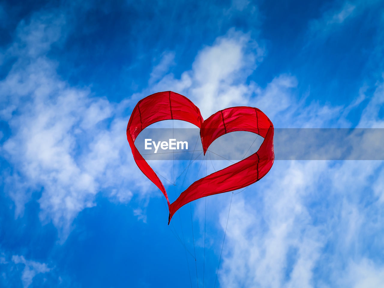 Low angle view of heart shape kite flying against sky