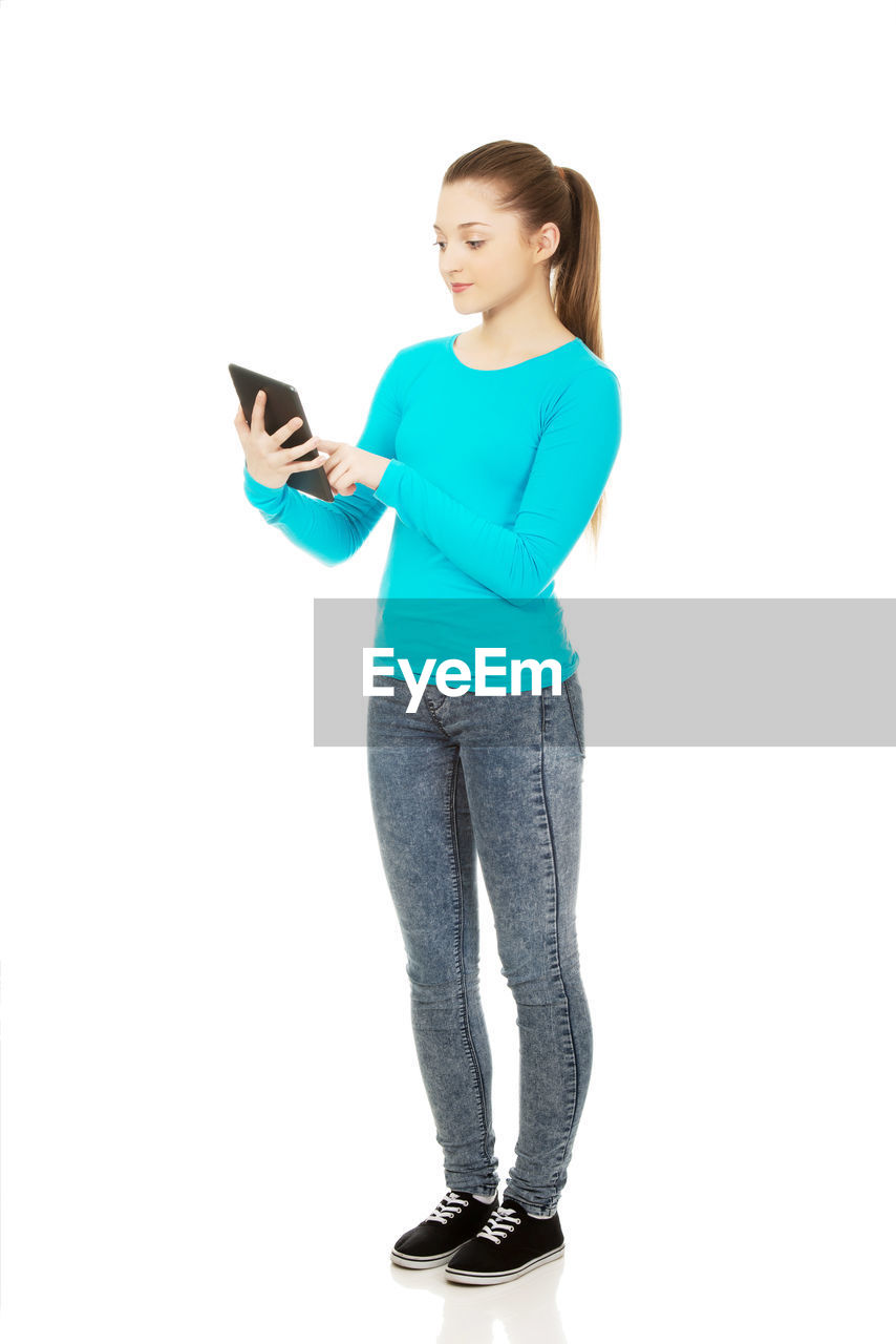 Young woman using digital tablet against white background