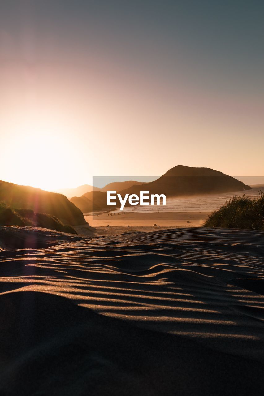 Scenic view of land against clear sky during sunset