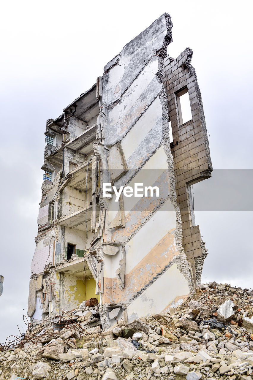 LOW ANGLE VIEW OF DAMAGED BUILDING AGAINST SKY