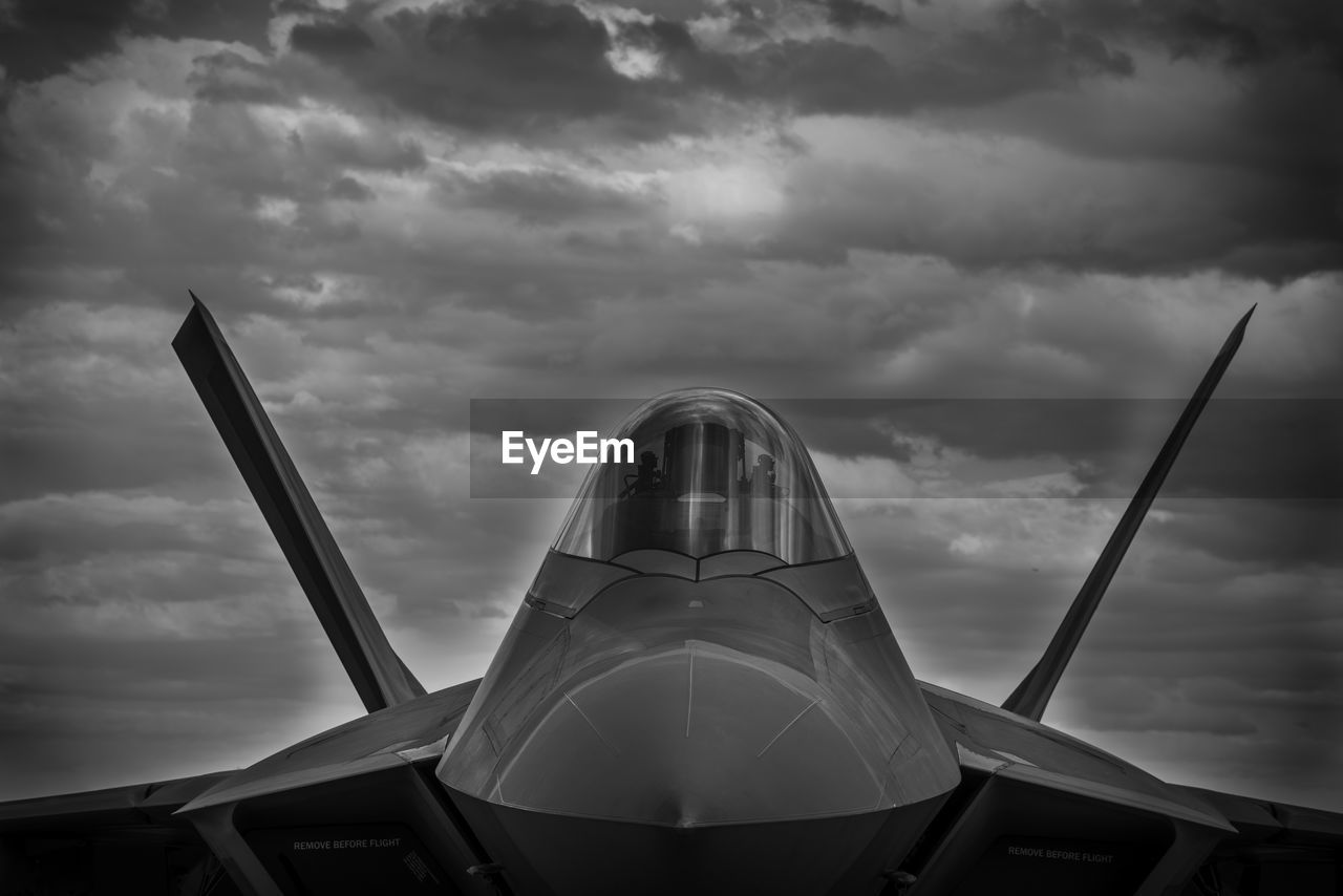 Military airplane against cloudy sky