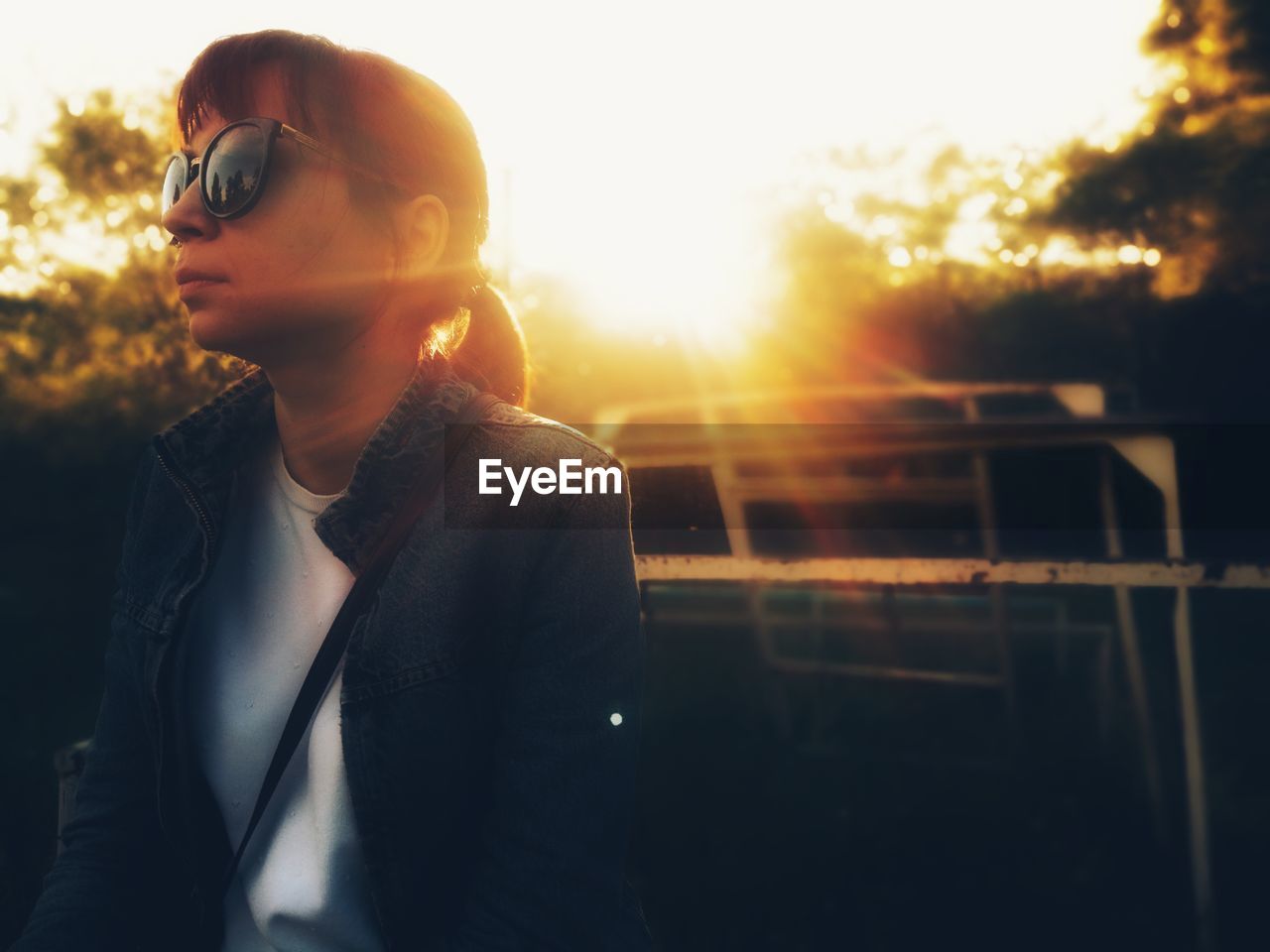 CLOSE-UP OF YOUNG WOMAN AGAINST SUNSET SKY