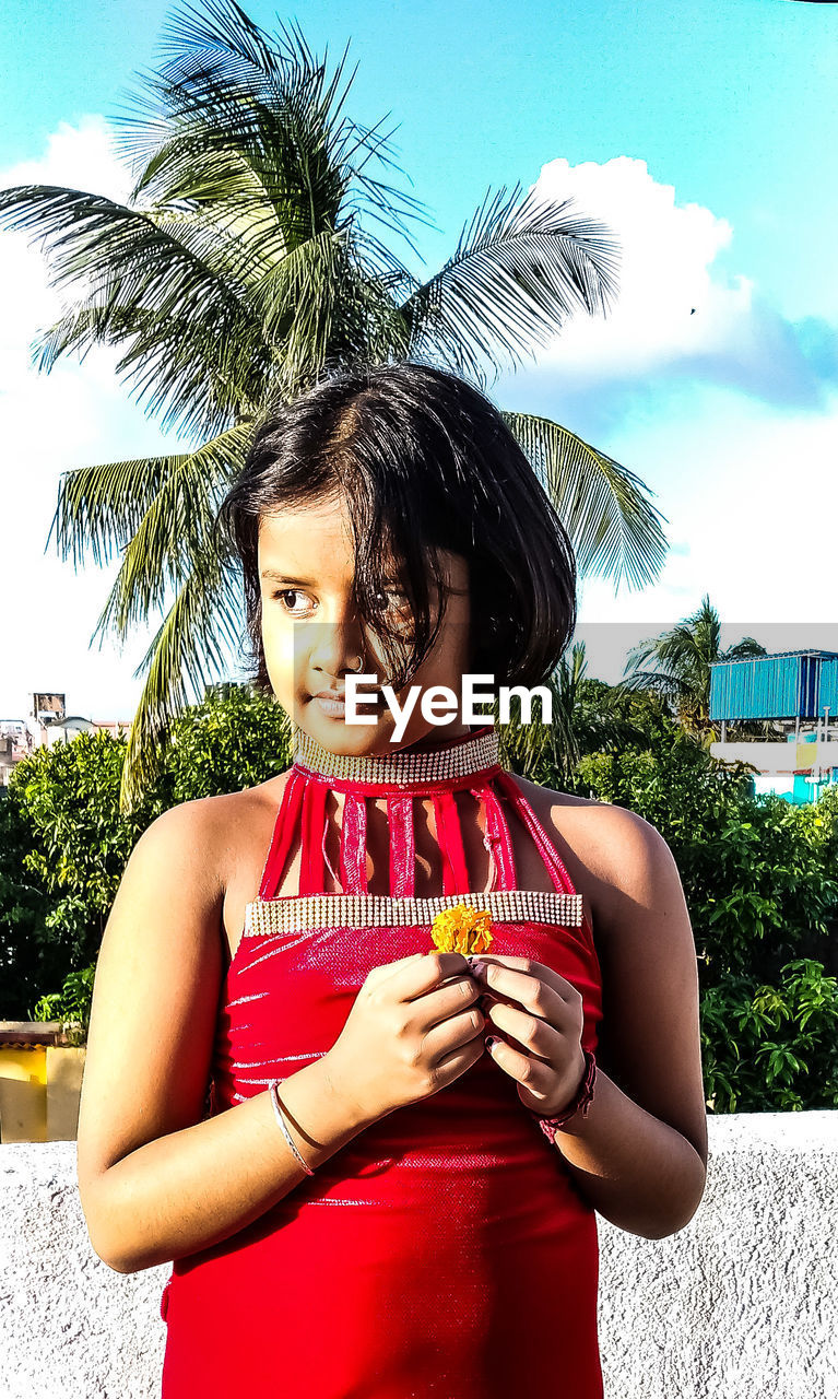 PORTRAIT OF A GIRL STANDING WITH PALM TREE