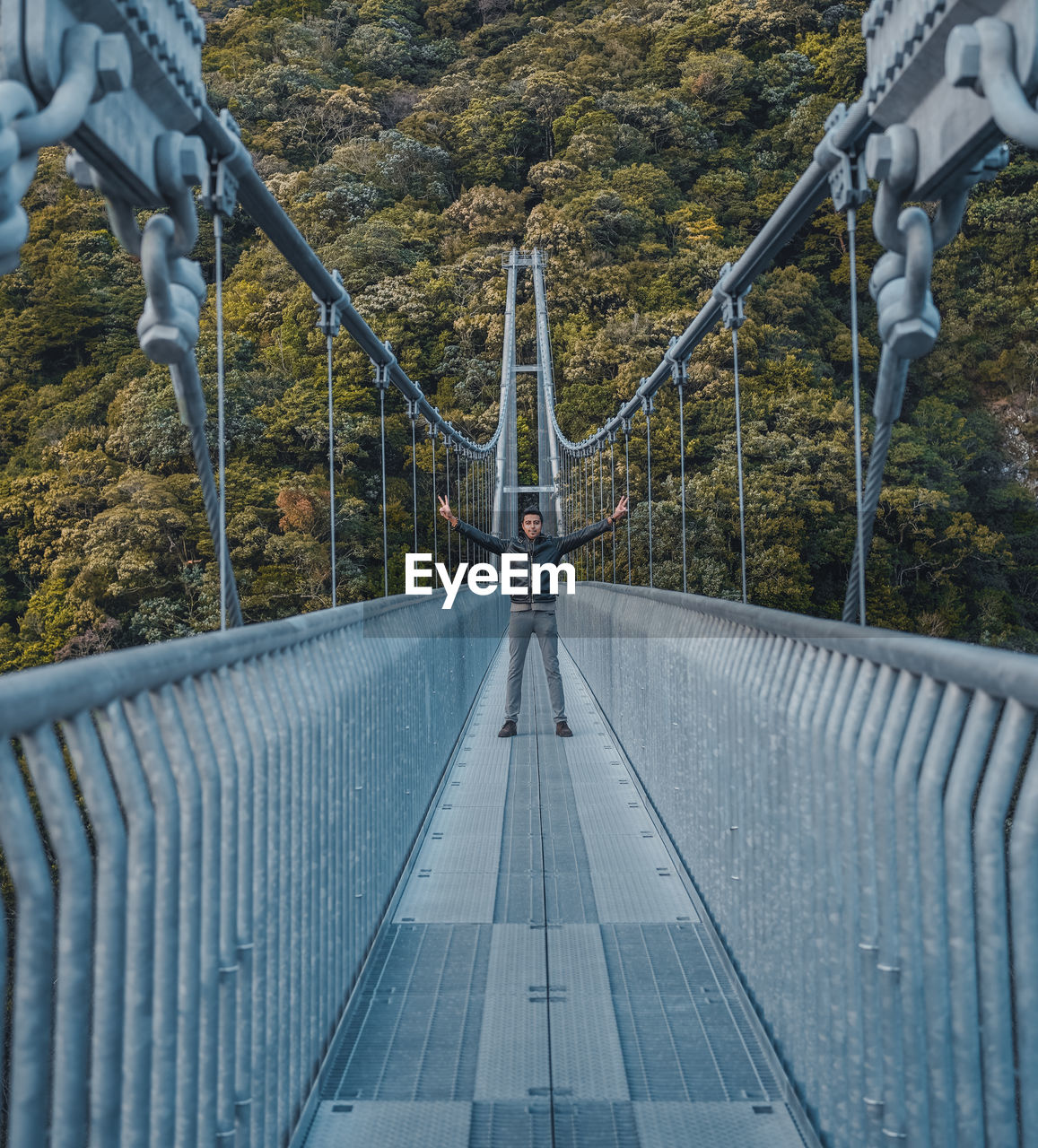 View of bridge with a man standing with hands raised