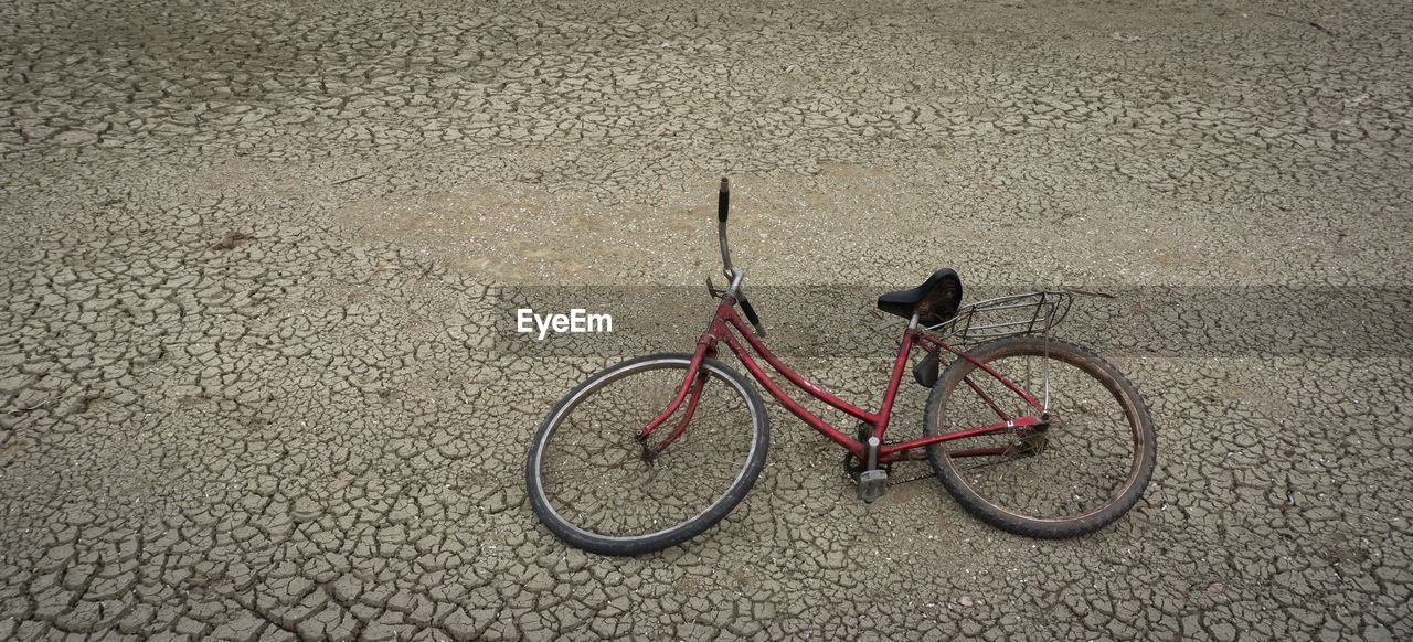 HIGH ANGLE VIEW OF BICYCLE PARKED ON ROAD IN CITY