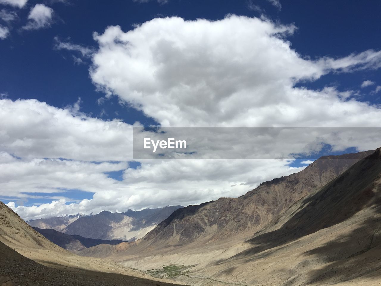 Scenic view of mountains against cloudy sky