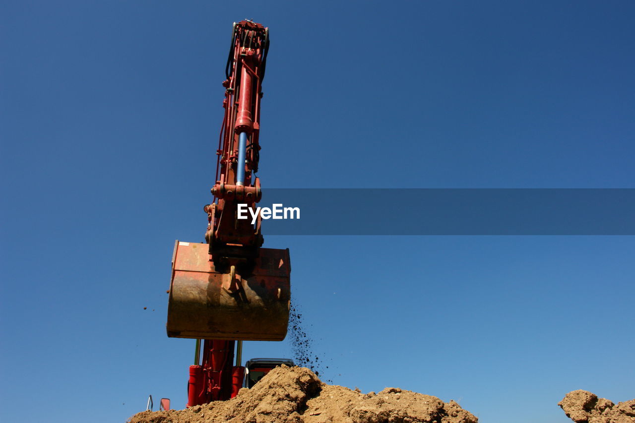 Low angle view of construction site against clear blue sky
