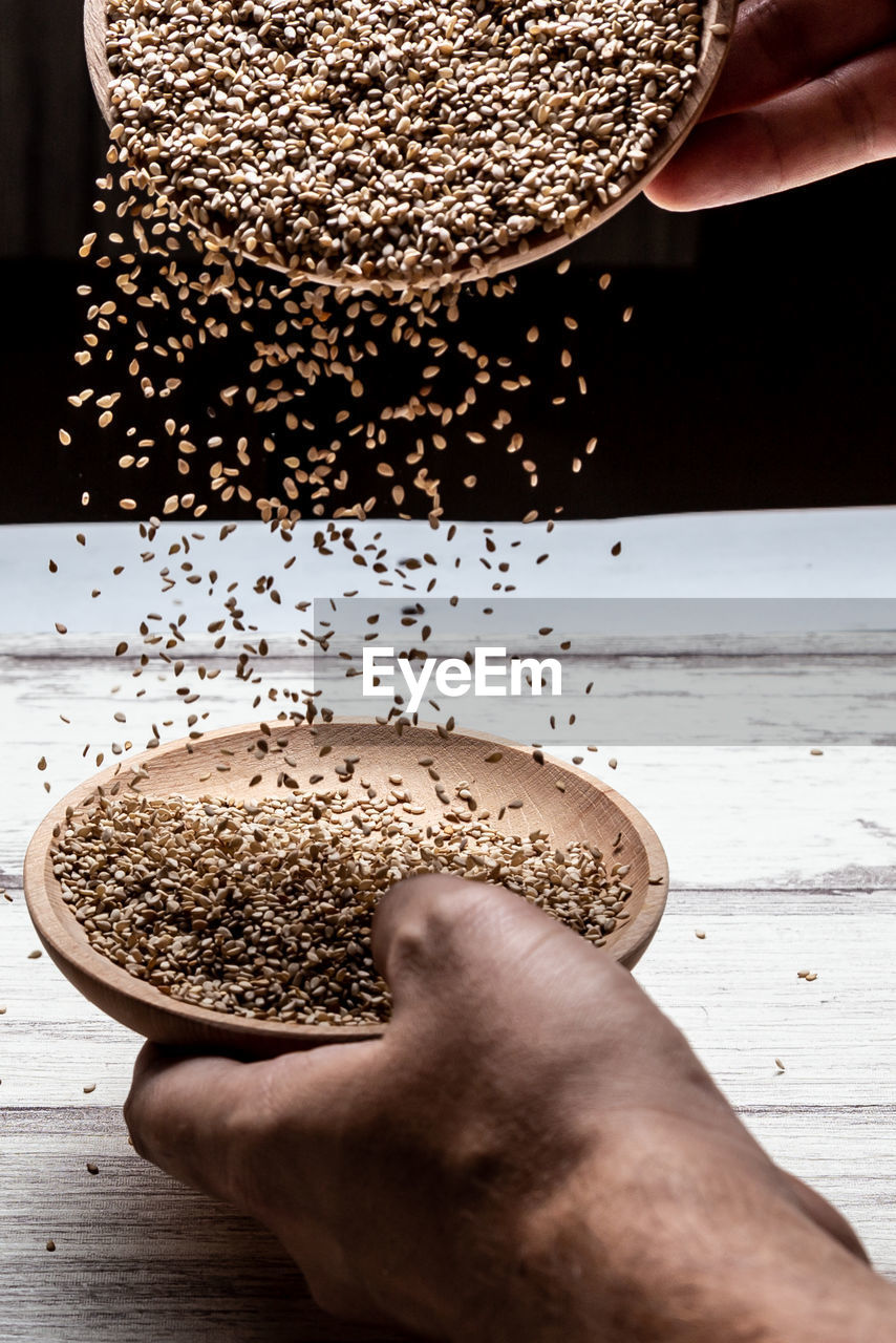 hand, food and drink, one person, food, holding, close-up, indoors, freshness, adult, studio shot, seed, wood