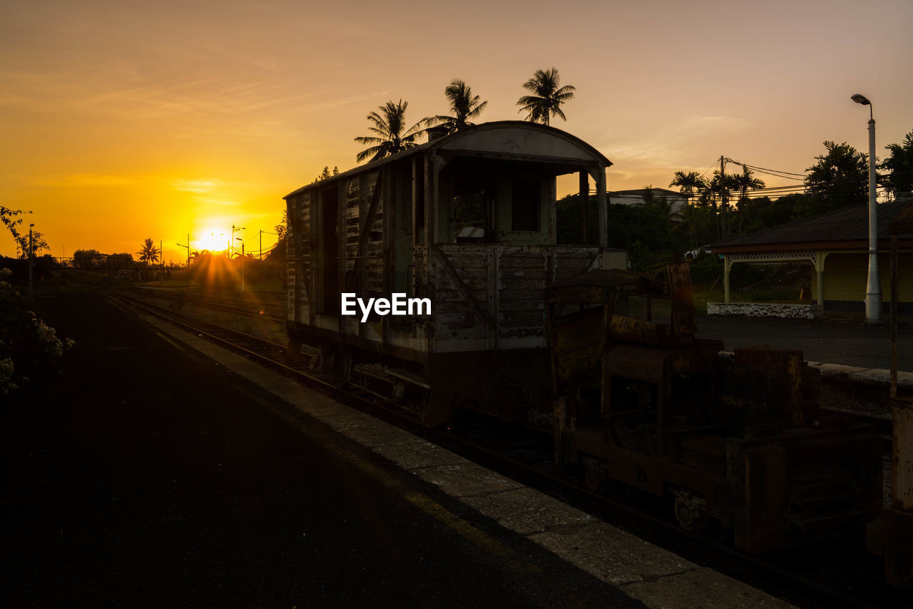 TRAIN AT RAILROAD STATION AGAINST SKY