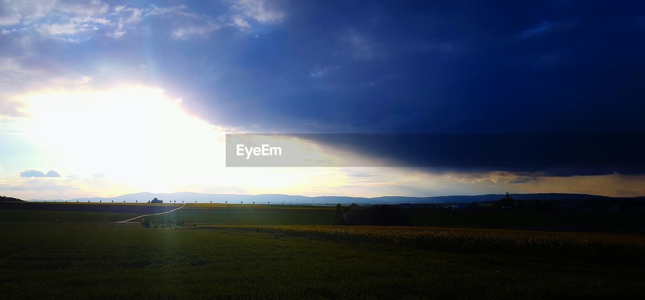 PANORAMIC VIEW OF FIELD AGAINST SKY AT SUNSET