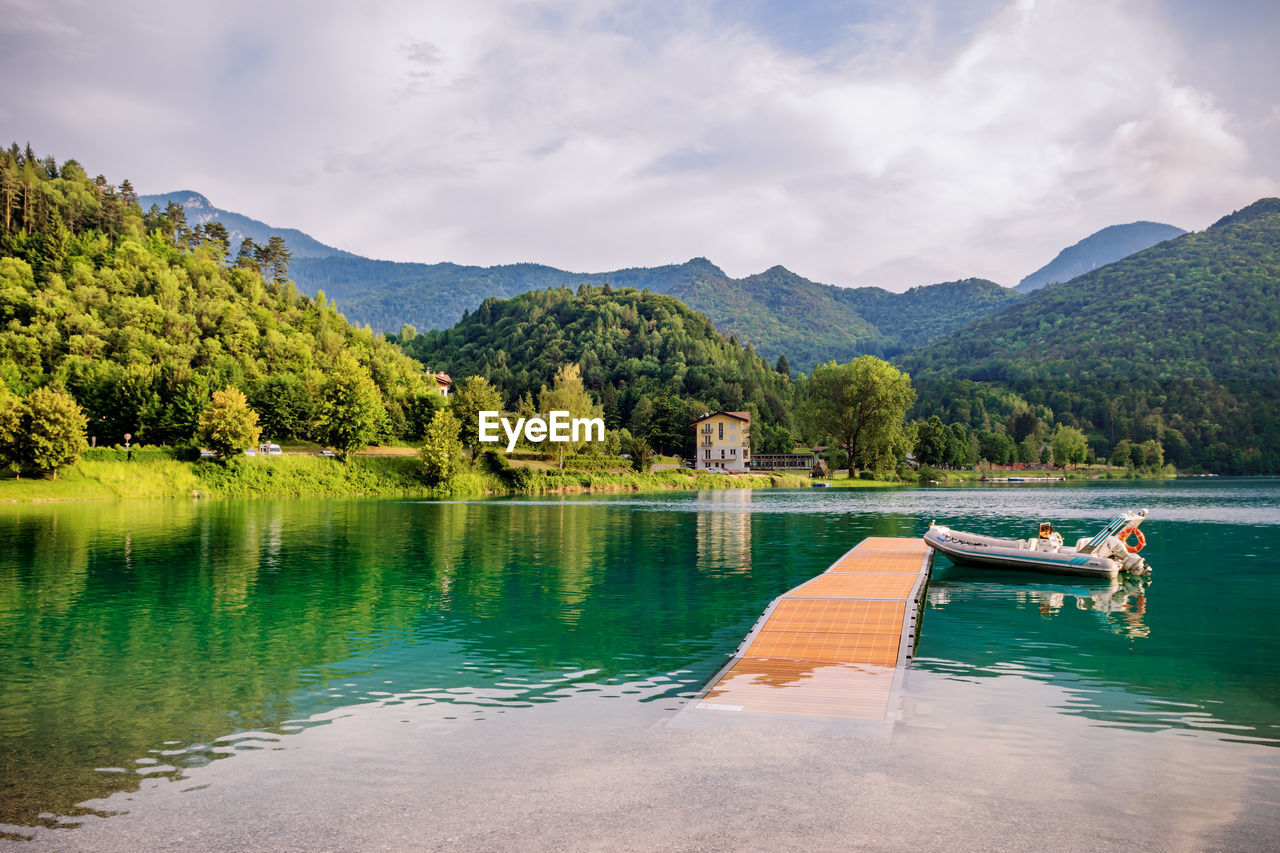 Scenic view of lake by mountains against sky