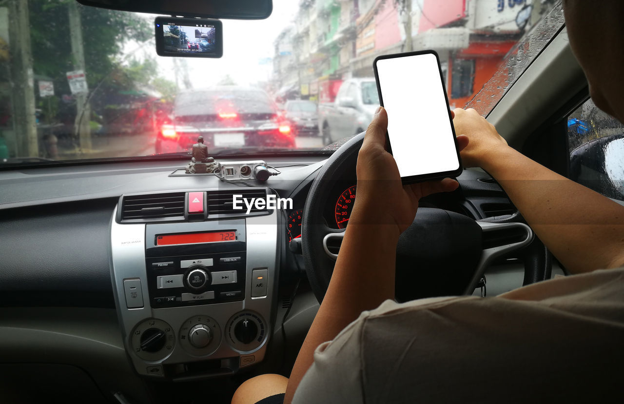 MIDSECTION OF WOMAN USING MOBILE PHONE IN BUS