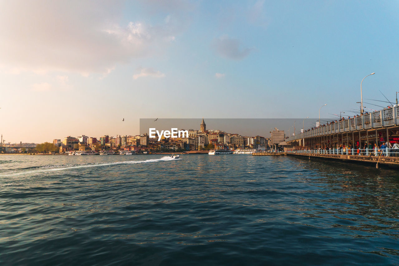 CITY BY SEA AGAINST SKY DURING SUNSET