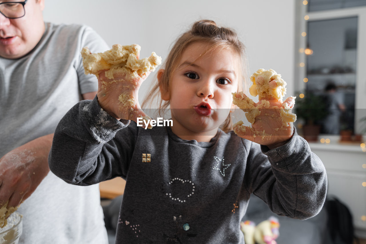 Portrait of young woman holding food at home