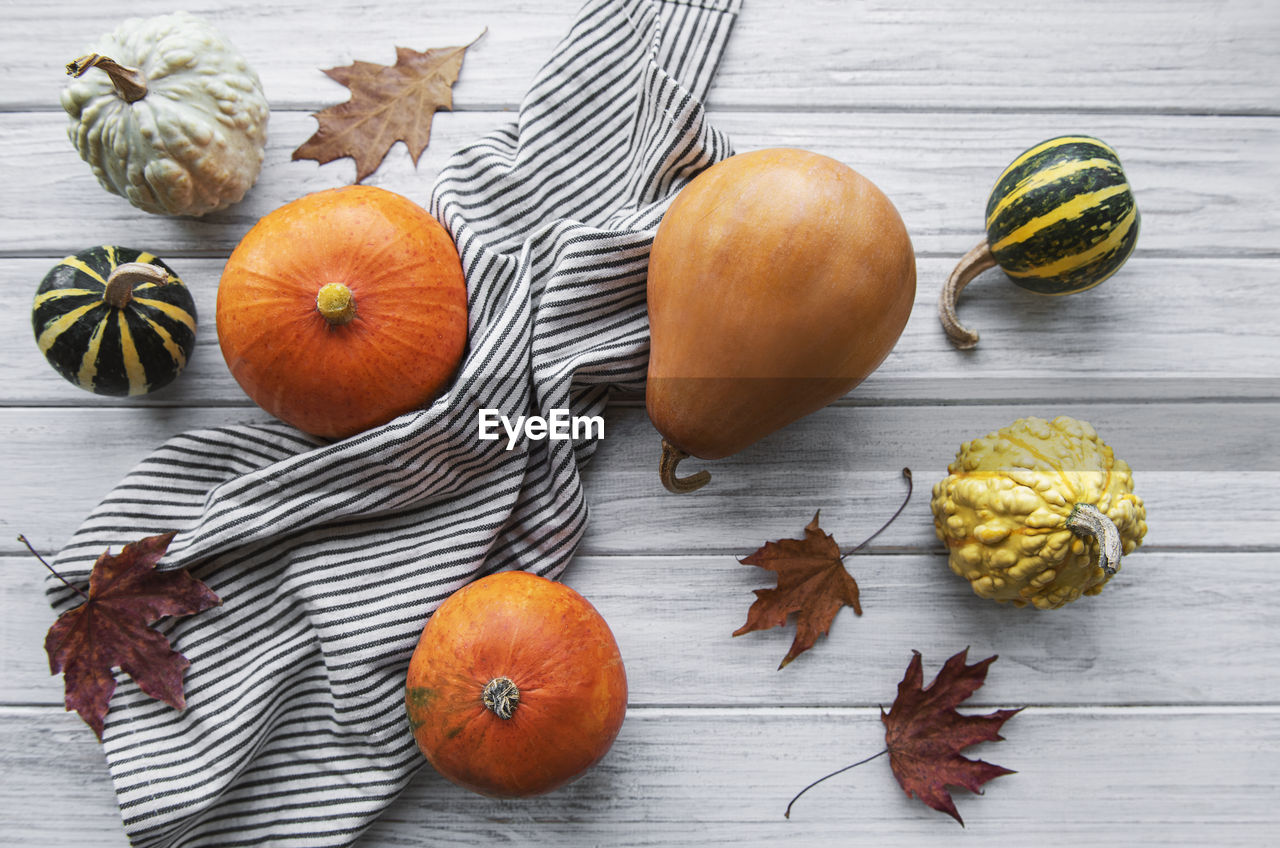 Autumn composition, cozy fall season, pumpkins and leaves on wooden background. 