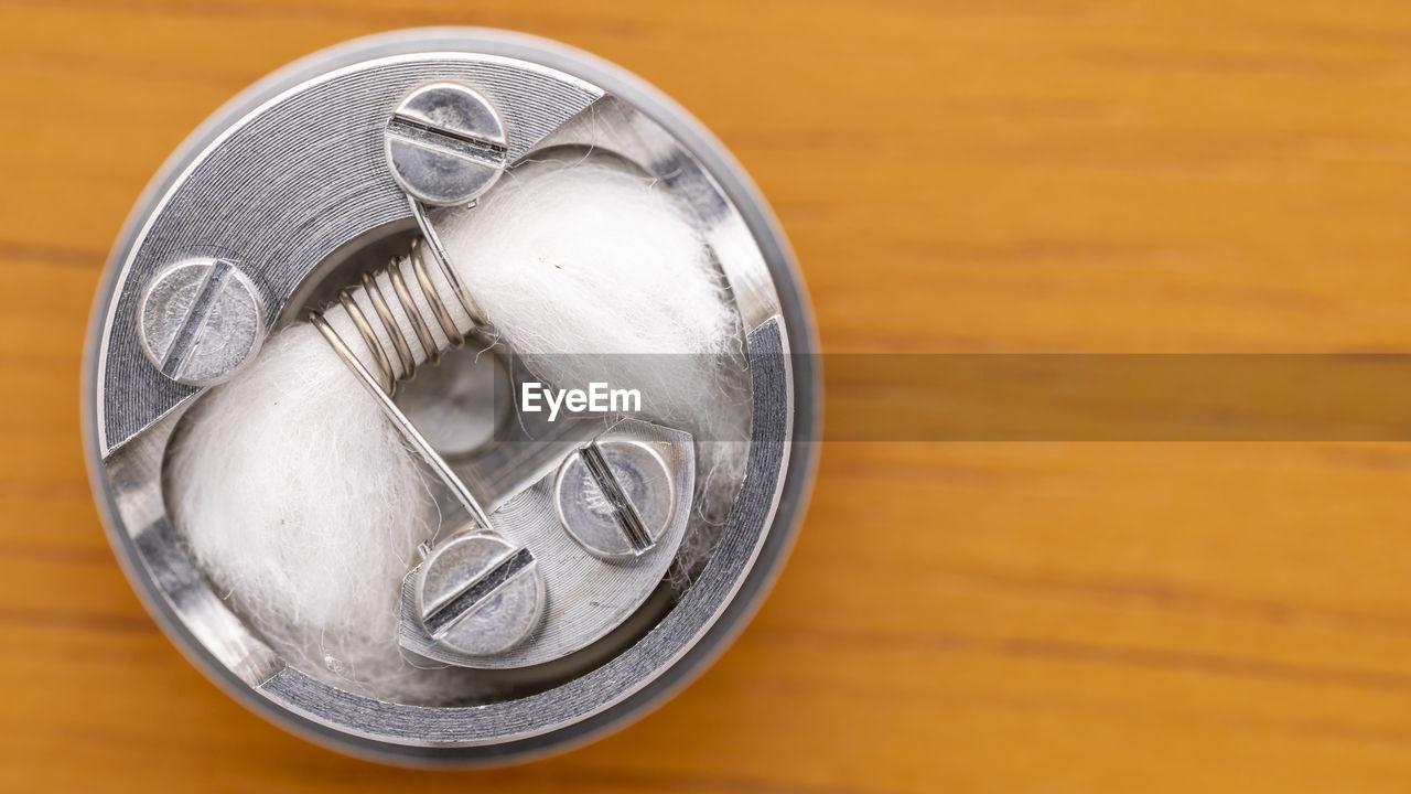 Top view, close up shot of single space coil with cotton wick in rebuildable dripping atomizer