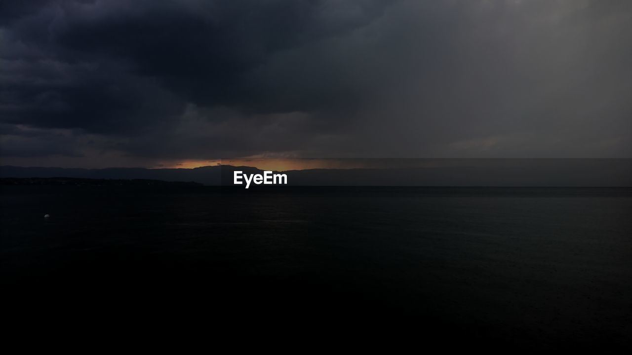 SCENIC VIEW OF SEA AGAINST DRAMATIC SKY