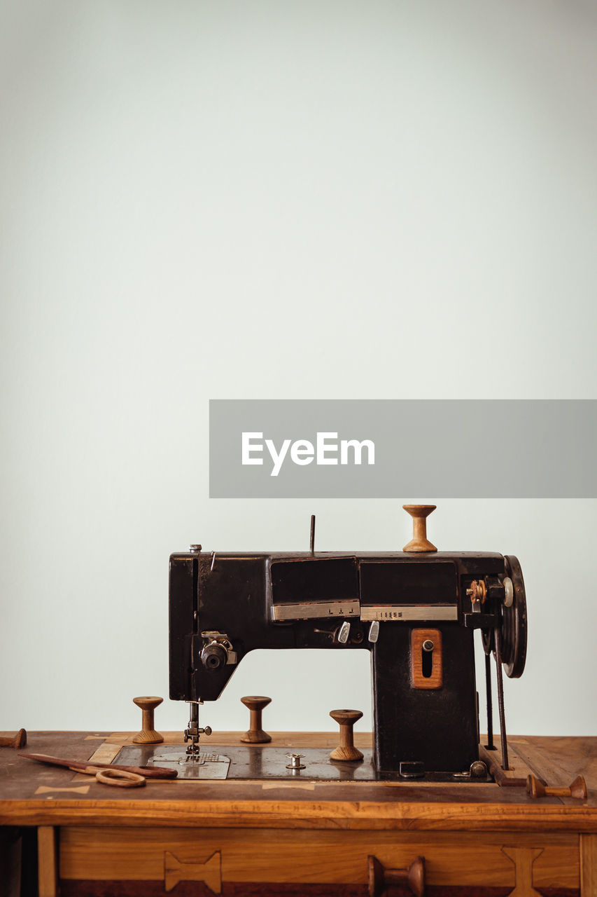 sewing machine, sewing, art, indoors, retro styled, home appliance, wood, table, copy space, technology, arts culture and entertainment, turntable, gramophone, music, equipment, history, machinery, the past, studio shot