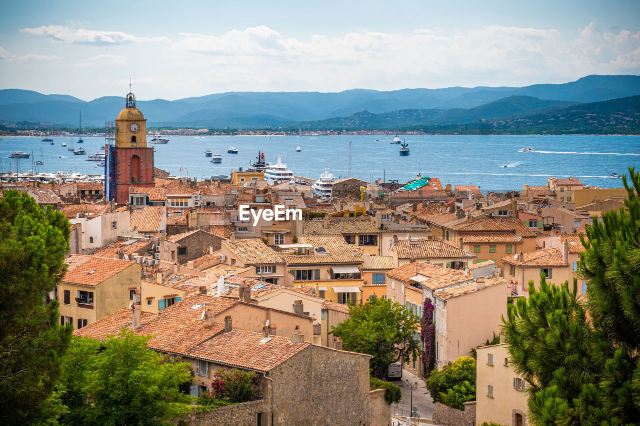 HIGH ANGLE VIEW OF TOWNSCAPE AGAINST SEA