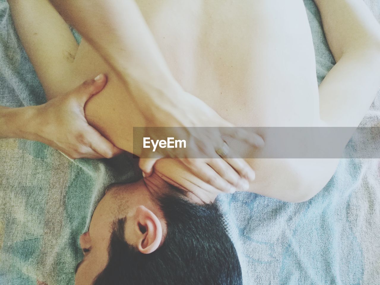 Cropped hands of massage therapist massaging shirtless male customer