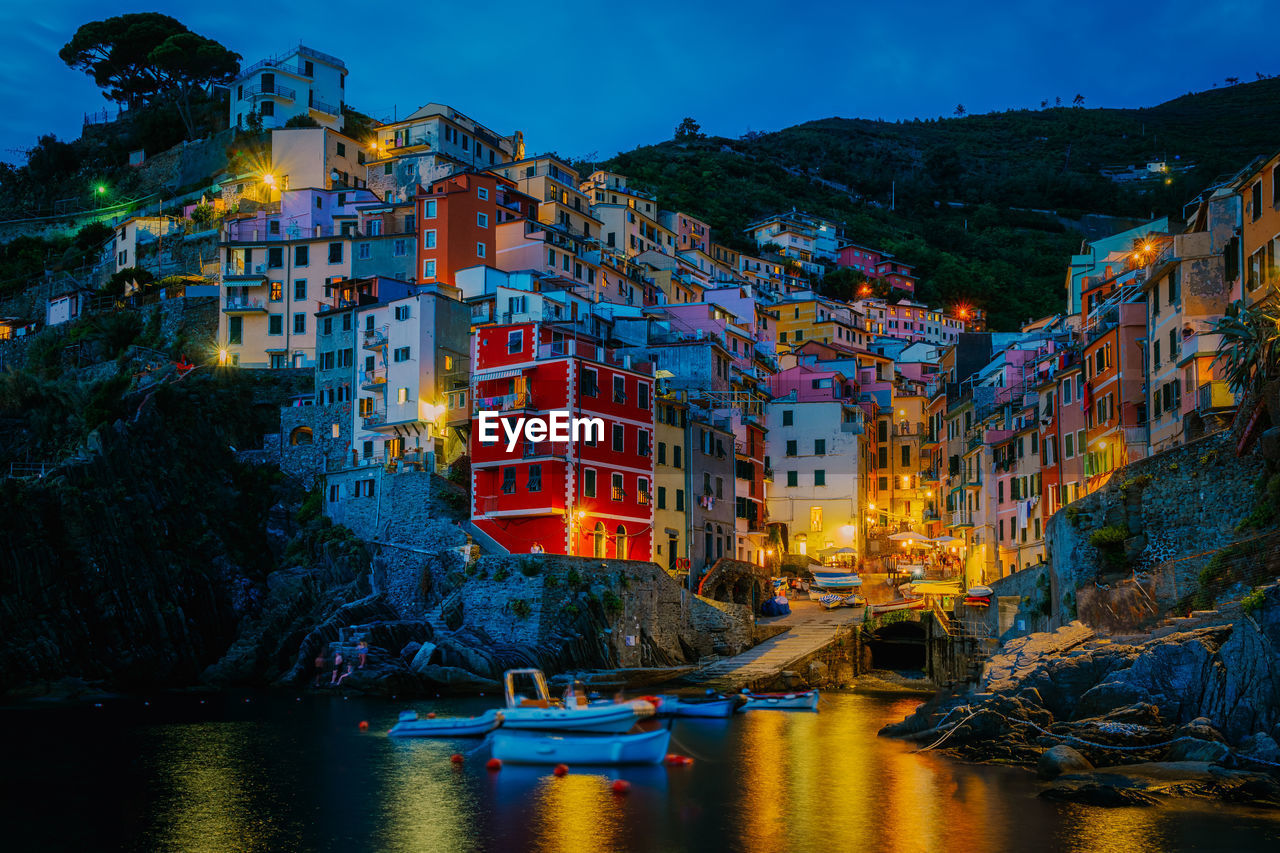 VIEW OF ILLUMINATED BUILDINGS AT WATERFRONT