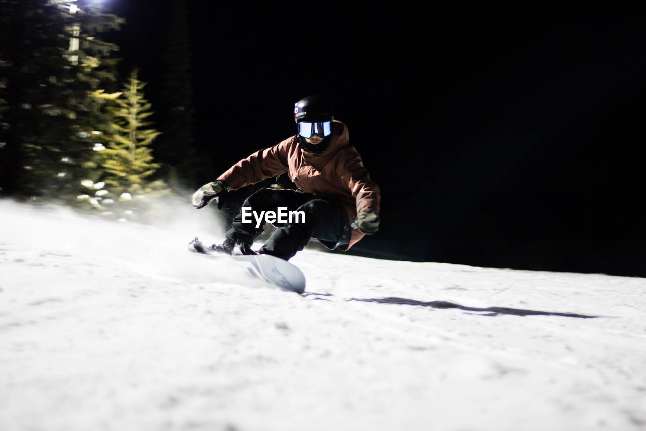 MAN SKIING ON SNOW IN MOUNTAINS