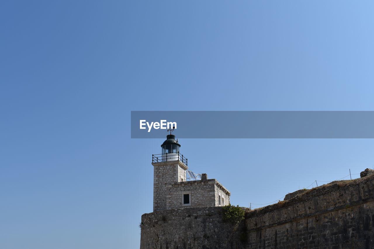 Low angle view of lighthouse against clear blue sky