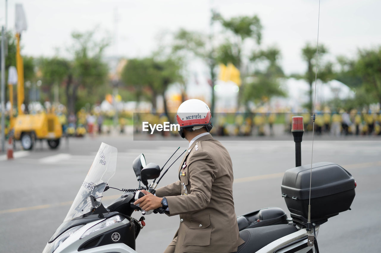 REAR VIEW OF SENIOR MAN RIDING BICYCLE ON ROAD