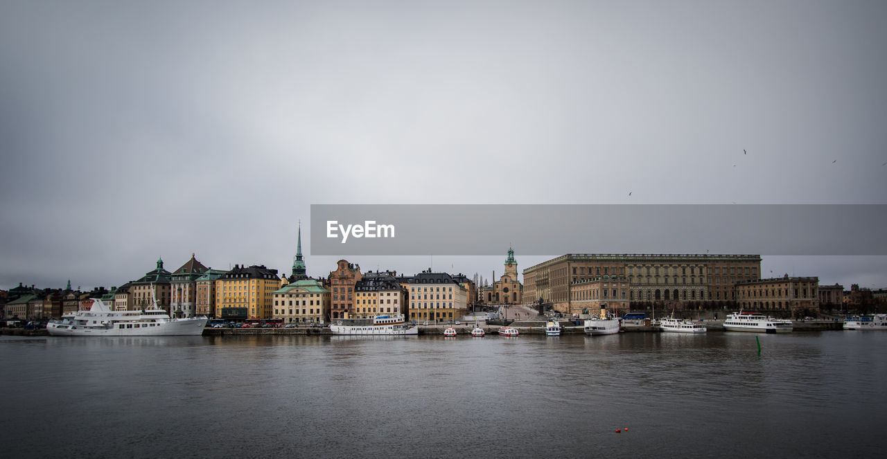 Boats in river with city in background