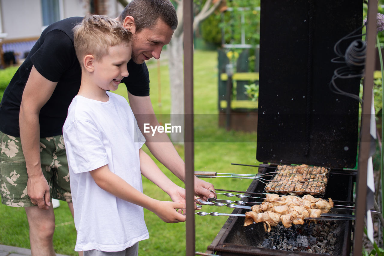 Young man preparing food on barbecue grill