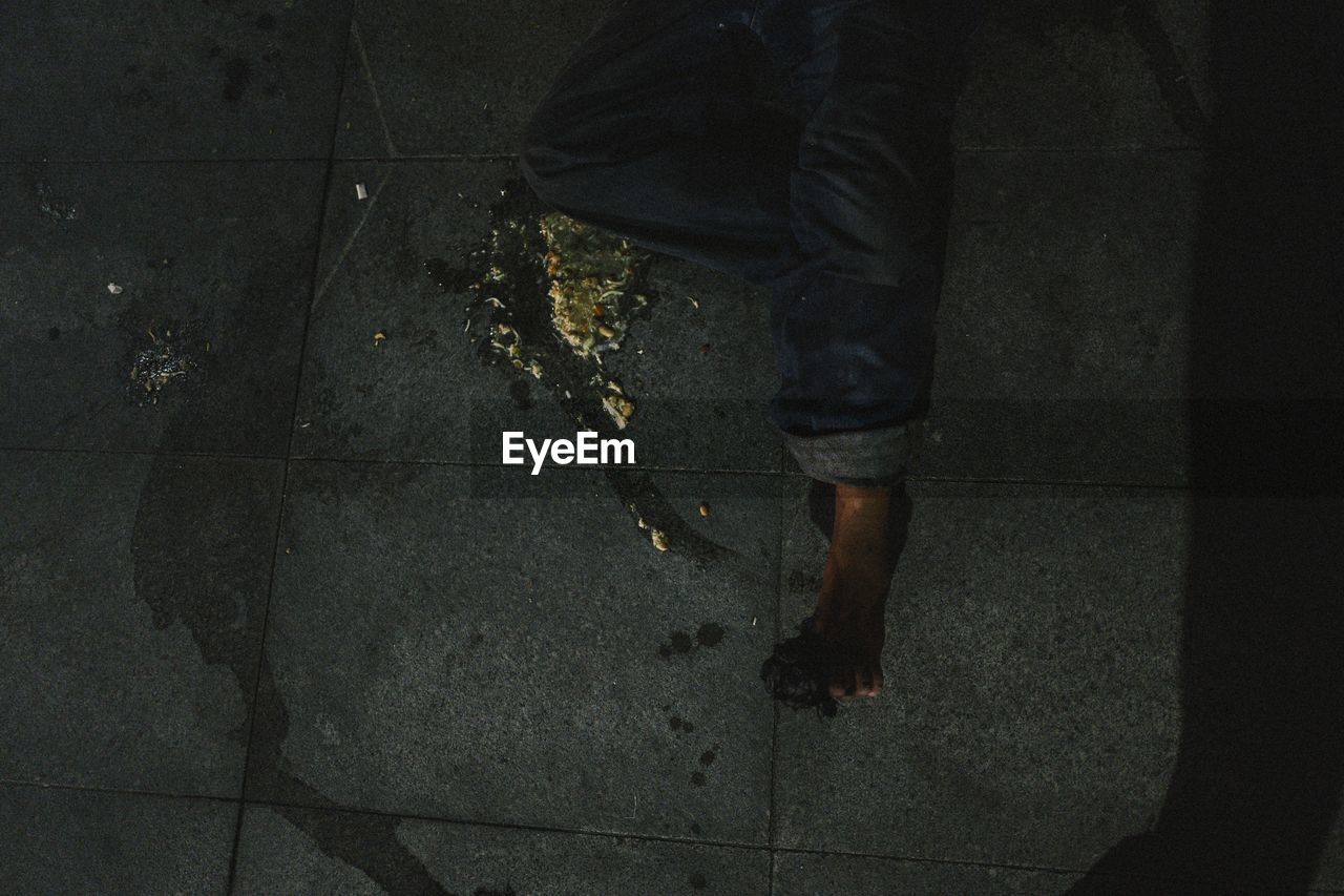 LOW SECTION OF MAN STANDING ON WET FLOOR