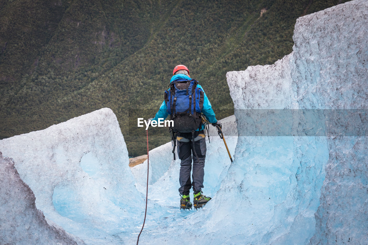 Rear view of hiker on glacier