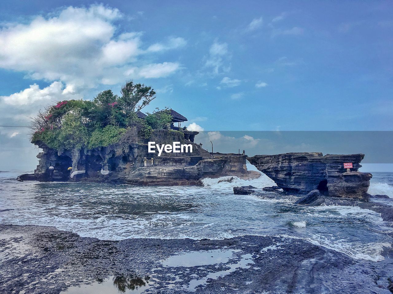 Rock formation on beach against sky