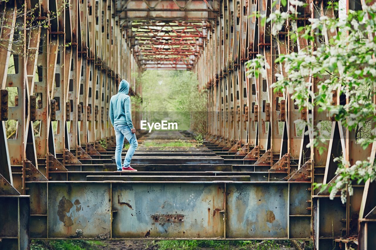 Full length of man walking on abandoned bridge
