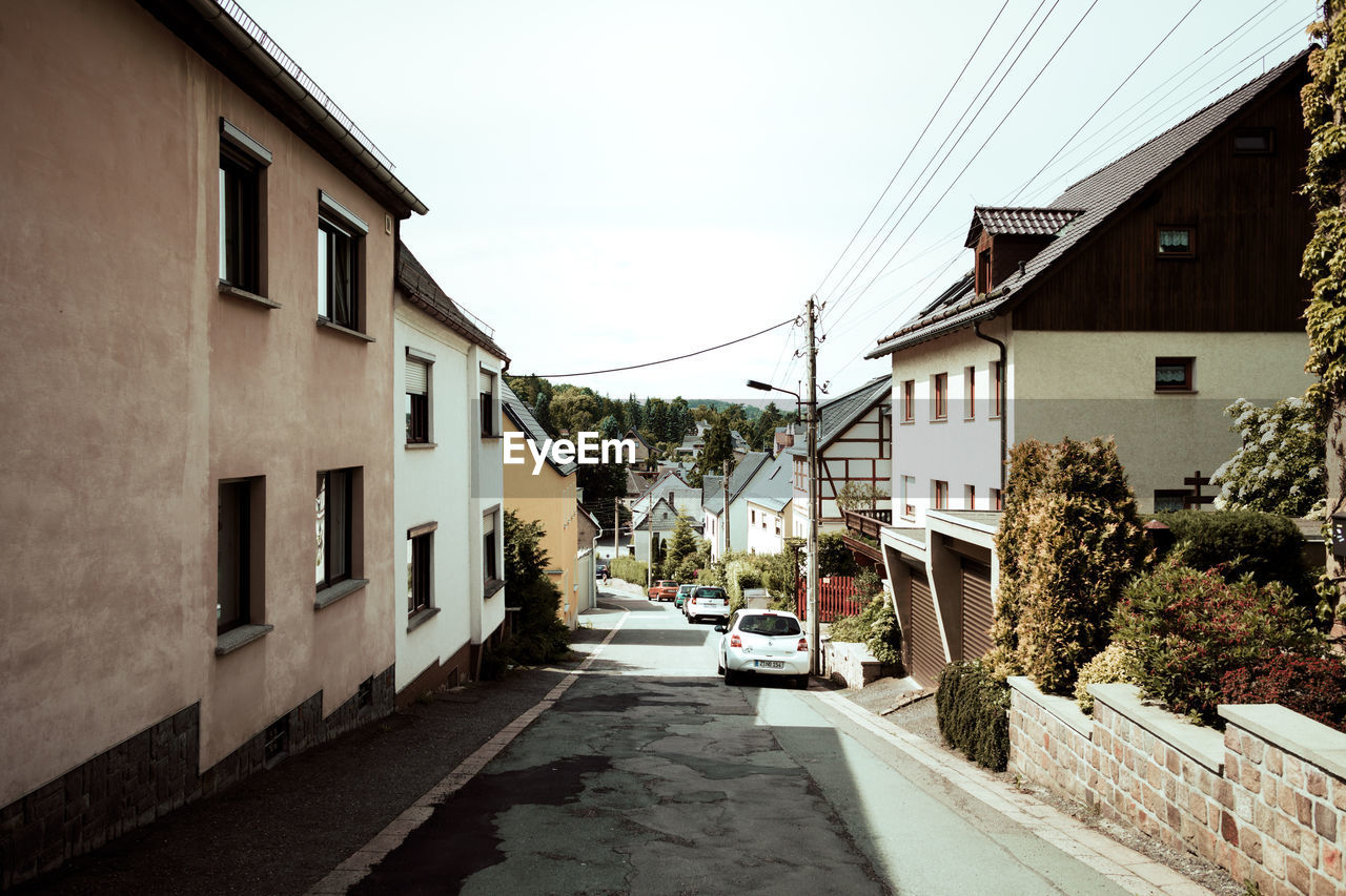 Street amidst houses against sky