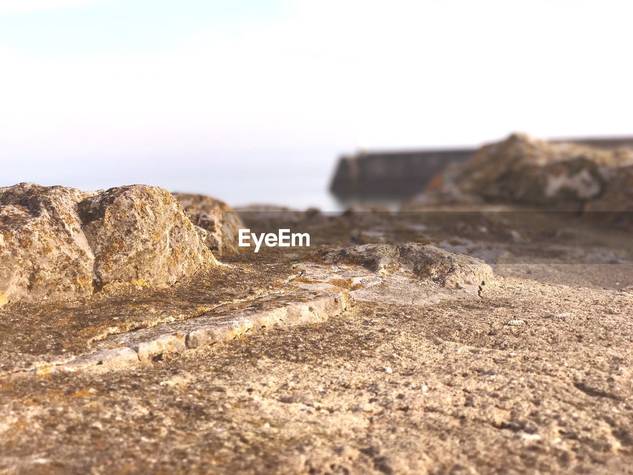 CLOSE-UP OF ROCKS ON LANDSCAPE AGAINST CLEAR SKY